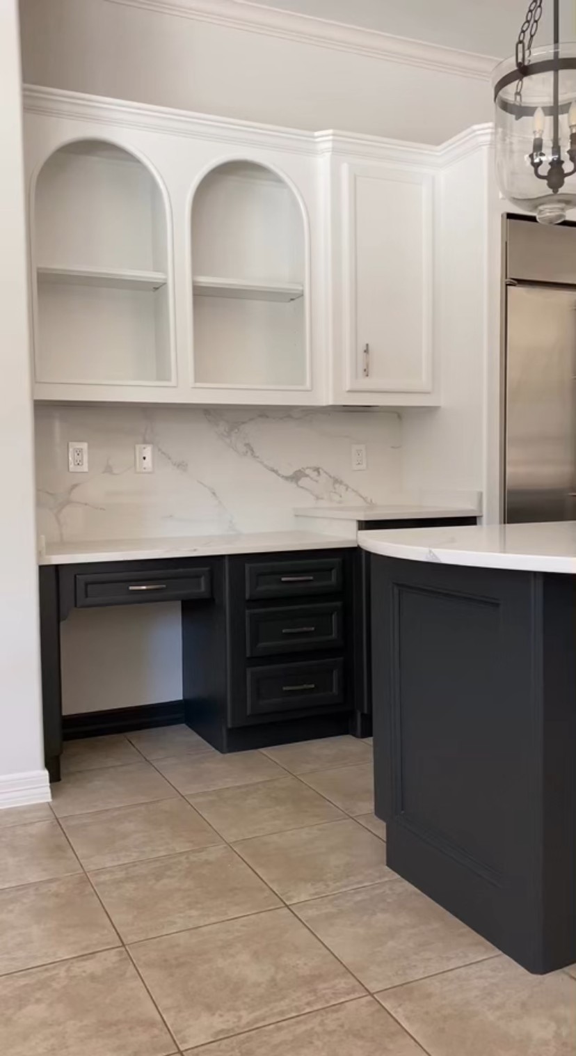 Arched display uppers with charcoal desk nook and island by Rodriguez Cabinets in Houston