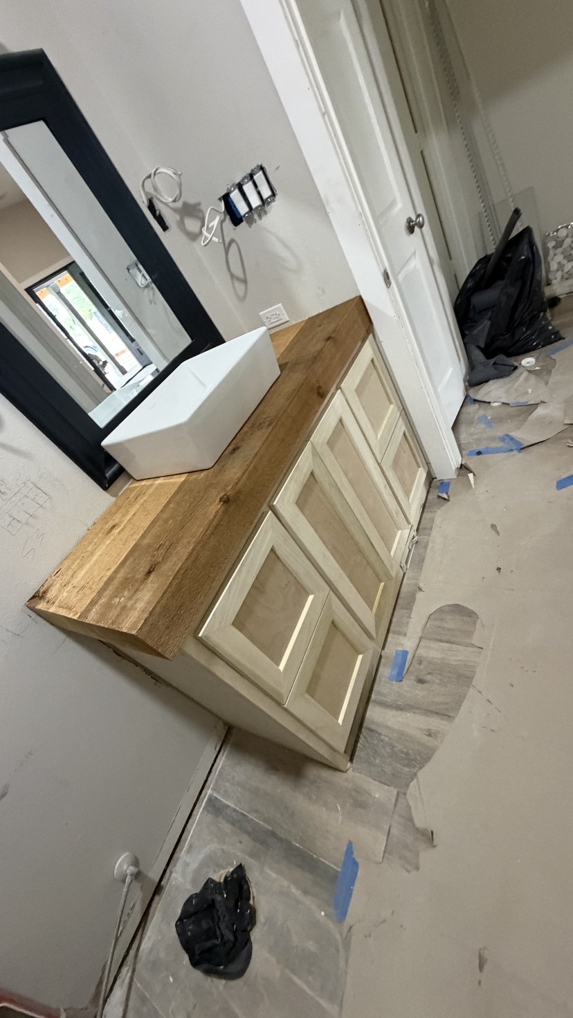 Raised panel vanity with live-edge wood top and vessel sink by Rodriguez Cabinets in Houston