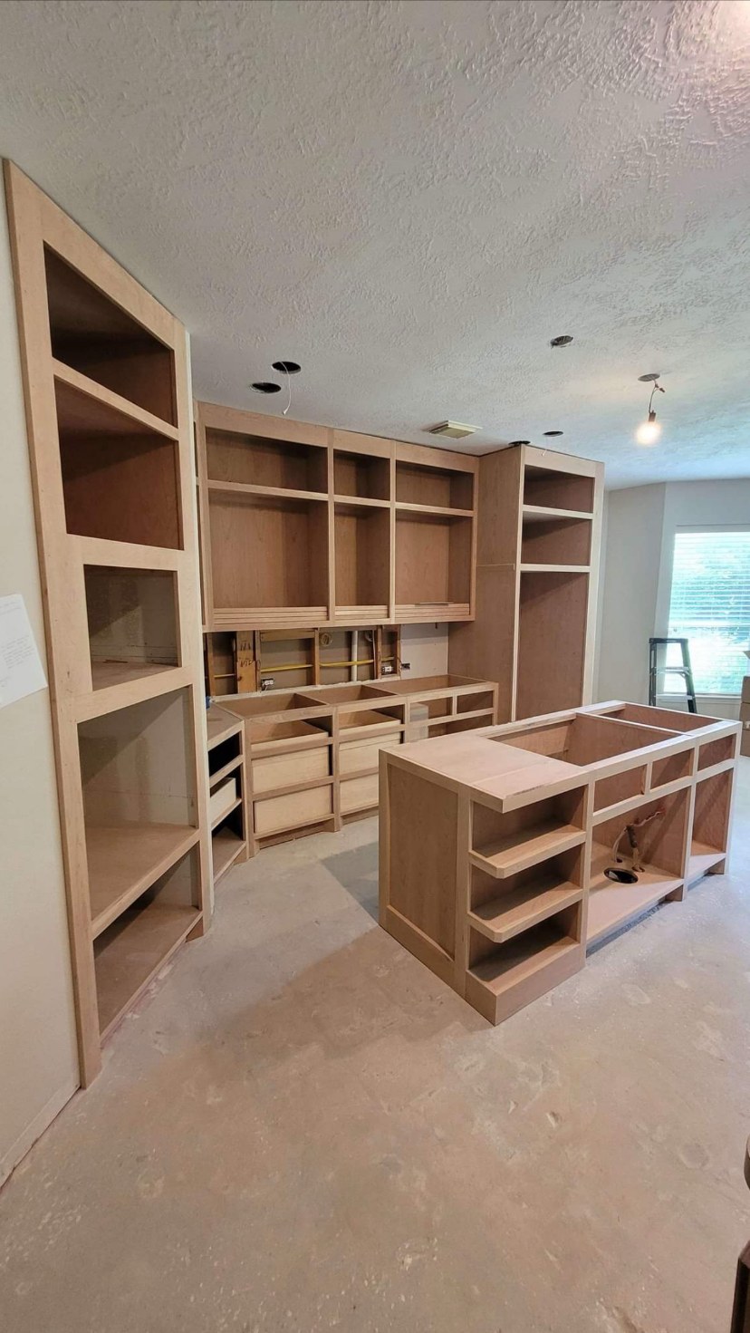 Built-in wall cabinet run with custom work island by Rodriguez Cabinets in Houston