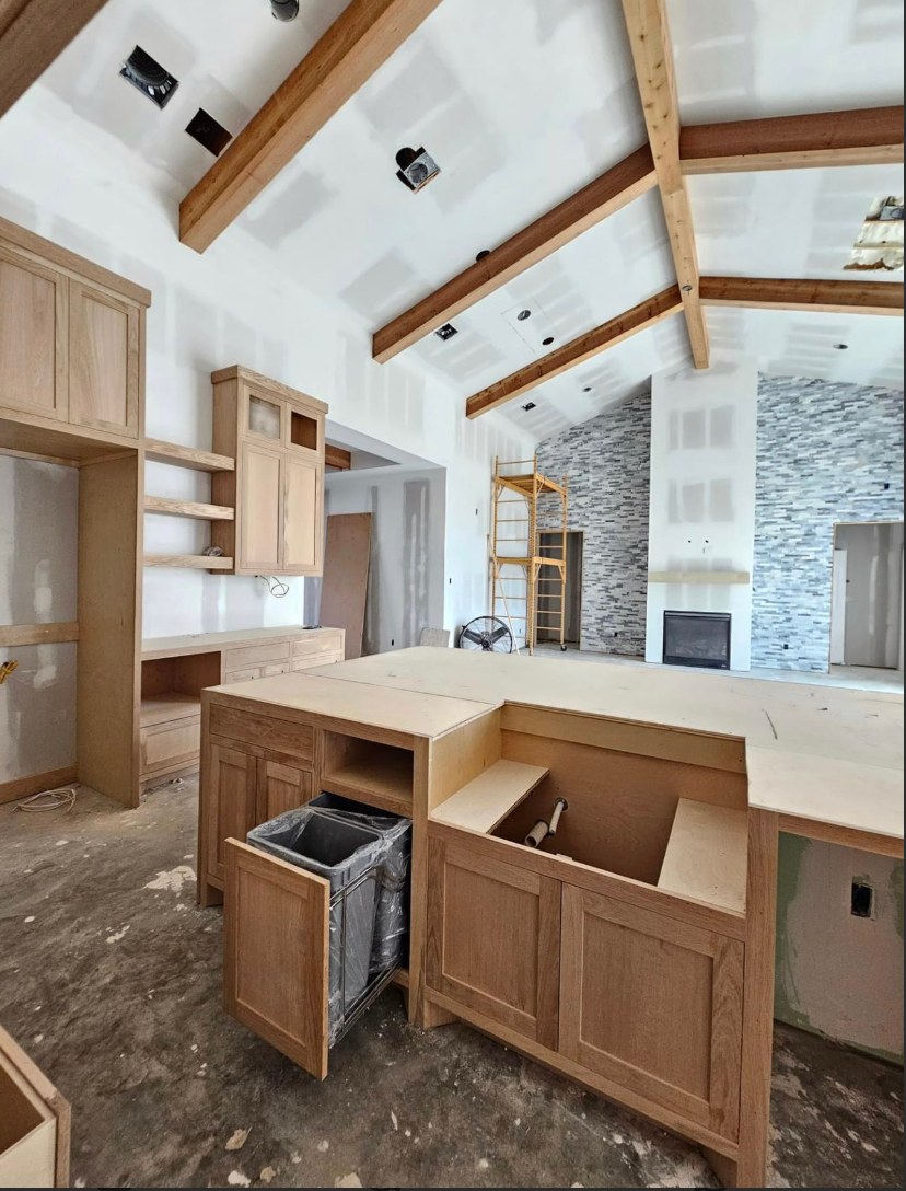 White oak kitchen with vaulted beam ceiling, floating shelves and island trash pull-out by Rodriguez Cabinets in Houston