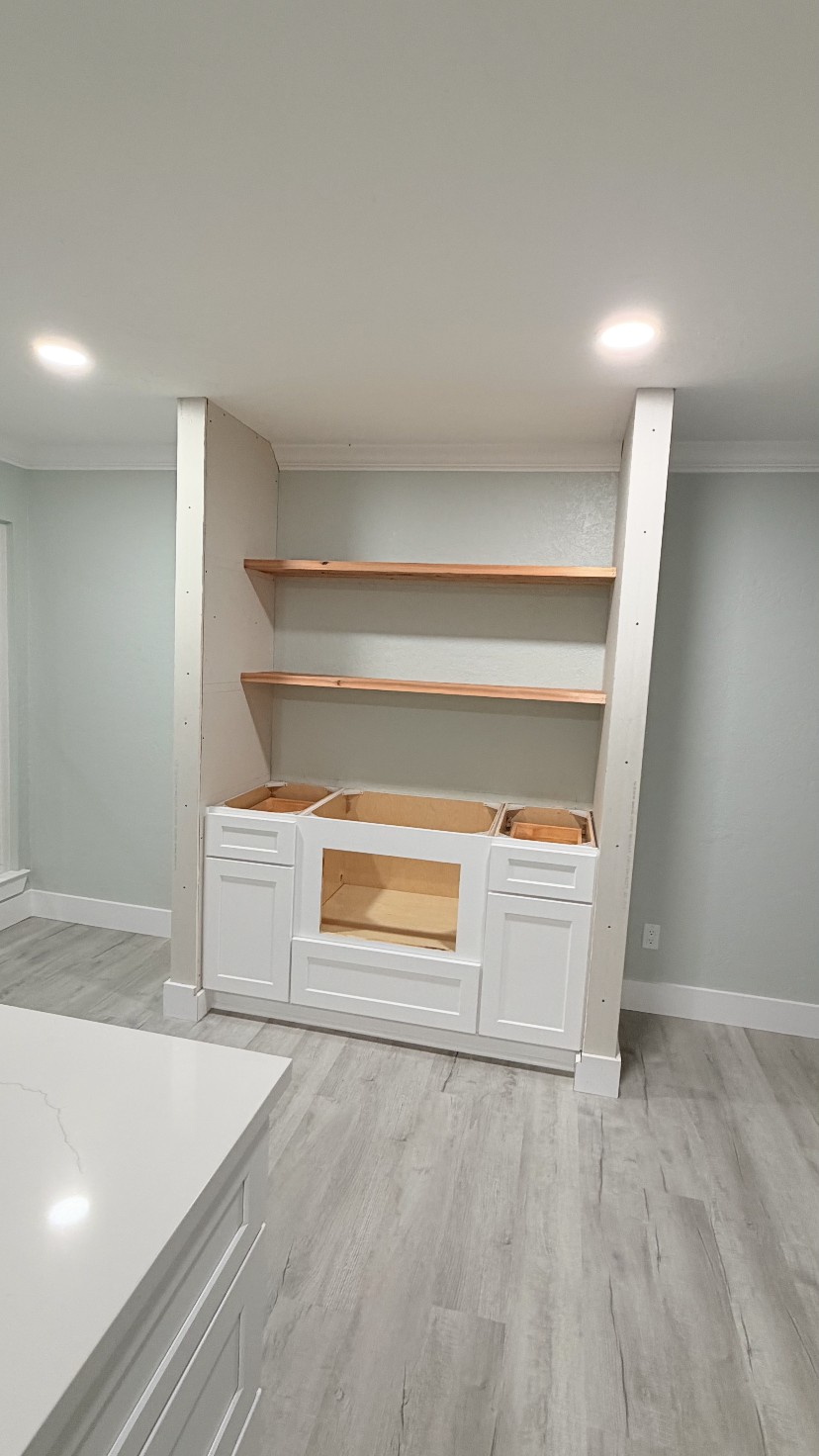 Built-in shaker base cabinets with floating wood shelves by Rodriguez Cabinets in Houston