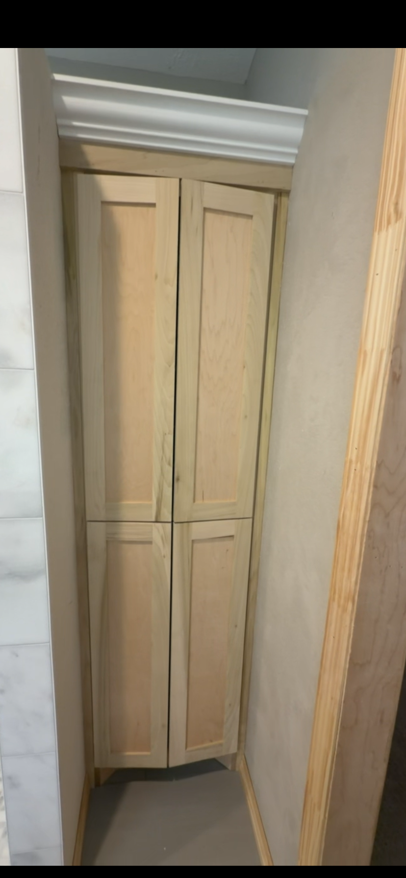 Closed space-saving natural maple corner pantry by Rodriguez Cabinets in Houston