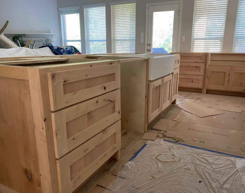 Knotty alder kitchen island and farmhouse apron sink base by Rodriguez Cabinets in Houston